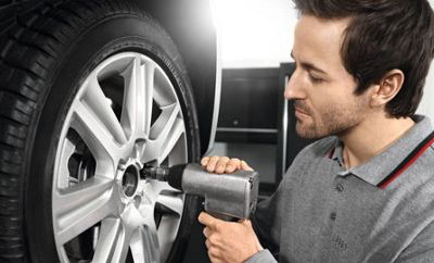 tecnician removing bolts from a wheel